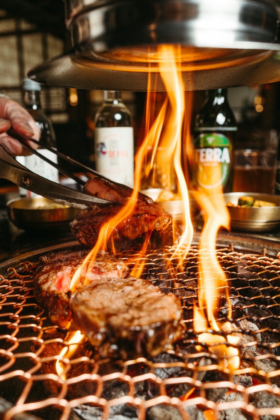 Marinated beef over an open flame at the table