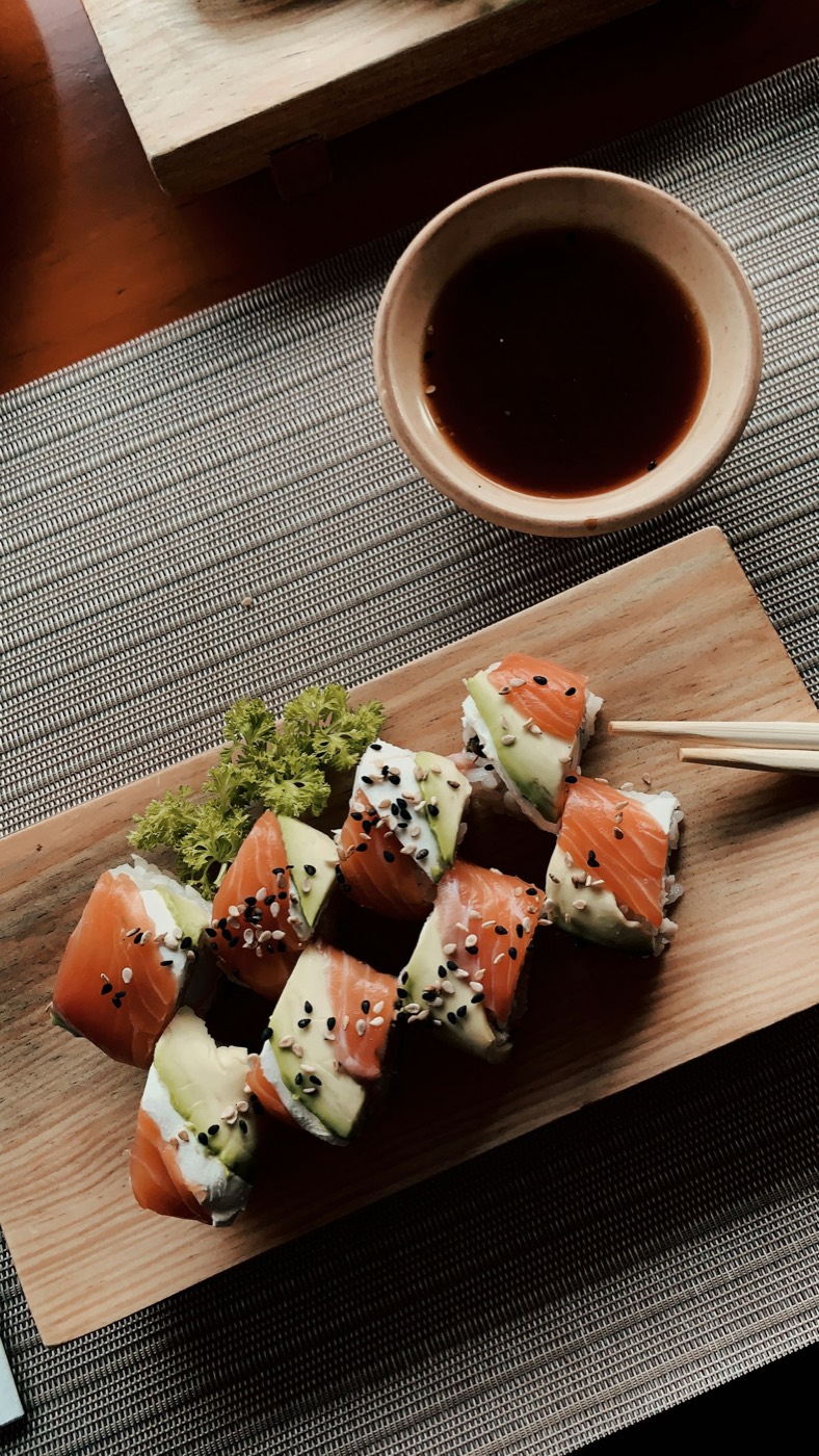 Salmon and avocado rolls on a wooden board