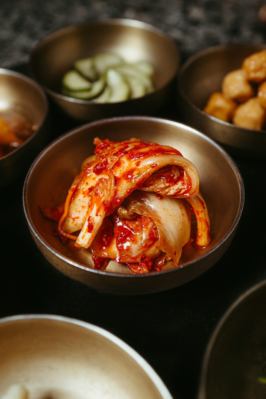 Kimchi and pickles in small brass bowls